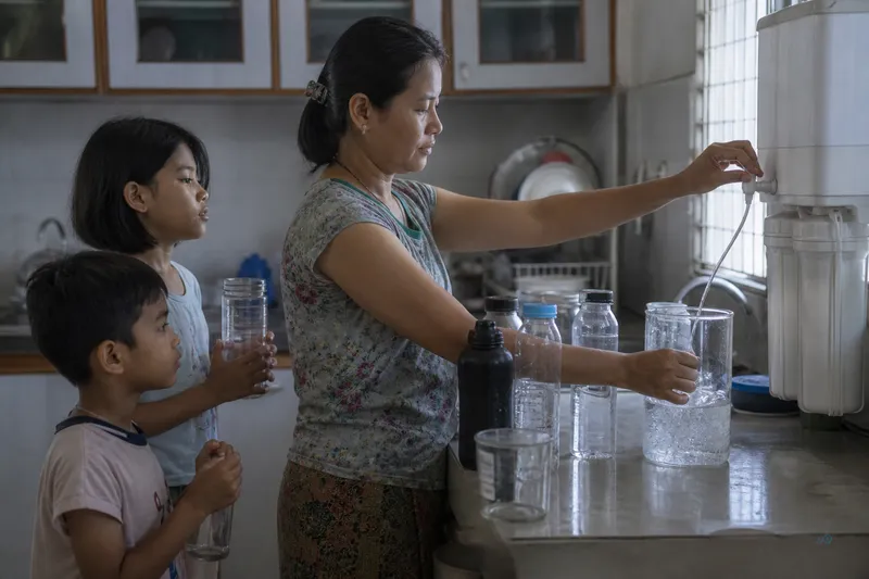 Slow RO tap while bottles wait on a Yangon kitchen counter
